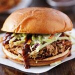 pulled pork on crusty bun with coleslaw and bbq sauce