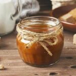 salted caramel sauce in small mason jar with jute tied around in a bow. thick salted caramel, homemade salted caramel sauce, easy salted caramel sauce recipe
