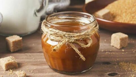 salted caramel sauce in small mason jar with jute tied around in a bow. thick salted caramel, homemade salted caramel sauce, easy salted caramel sauce recipe