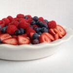 A white bowl filled with berries and blueberries.