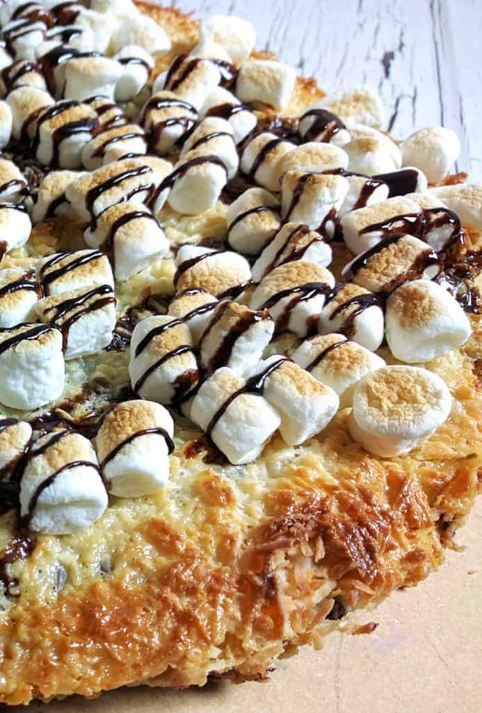 S'mores Magic Cookie Bar Pizza. The ooey gooey combination of chocolate, coconut, and graham crackers topped with a thick layer of sweetened condensed milk – oh wow! You know what I mean!