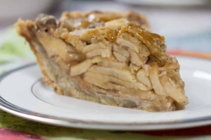 close up image of a slice of dutch apple pie on a white plate