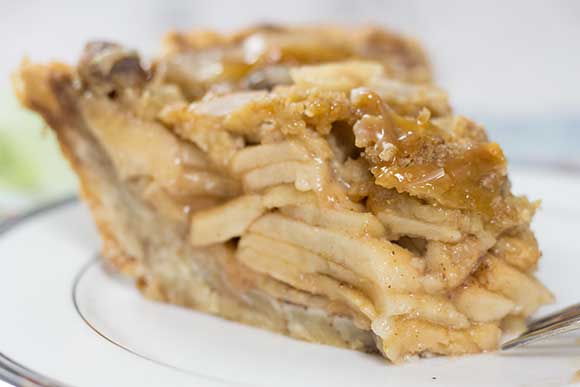 side view of a Slice of Dutch Apple Pie in white pie plate