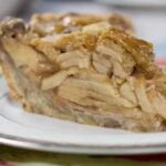 Slice of Apple Pie with cinnamon roll pie crust on a white pie plate