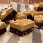 several maple fudge toffee bars scattered on a white and grey linen towel