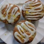 three lemon poppy seed muffins on a white china plate