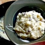 old fashioned rice pudding close up in brown pottery bowl with slowcooker in the background.