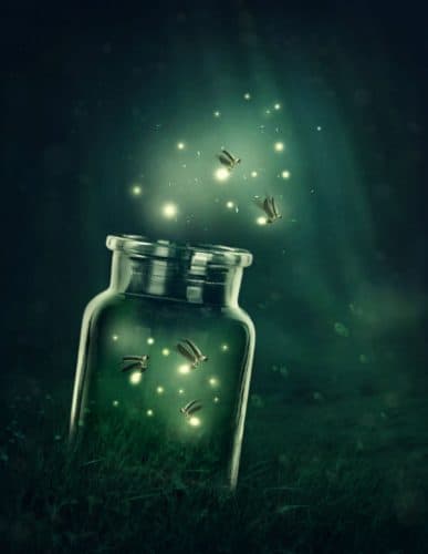 mason jar full of fireflies on a green misty background