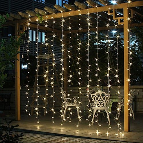 curtain of mini lights with white cast iron chairs behind on patio