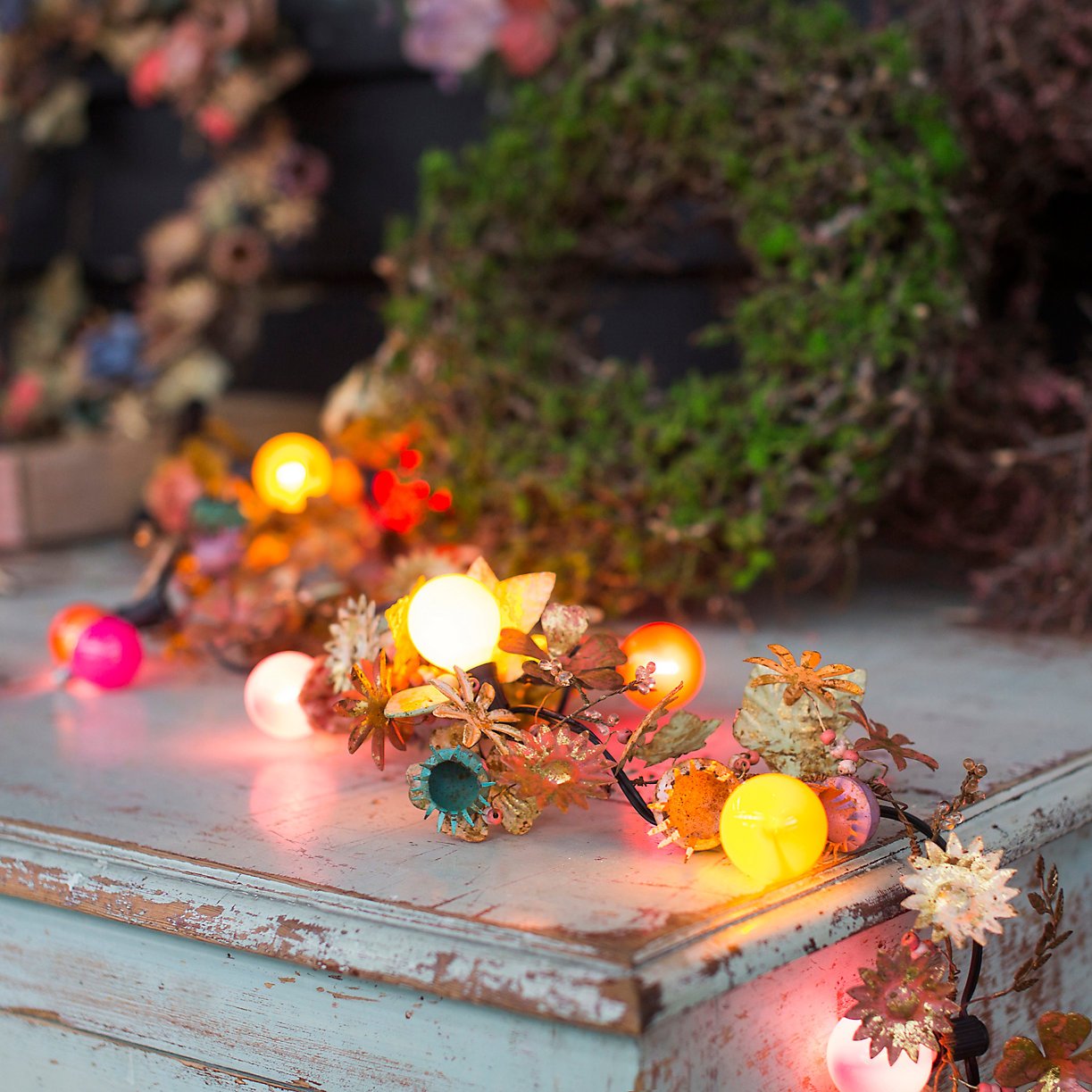 fairy light garland in pinks, yellows, blues on weathered blue dresser