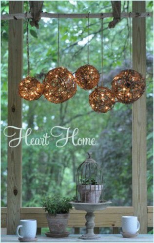 glittering globes hanging outdoors with text hear home in white lettering