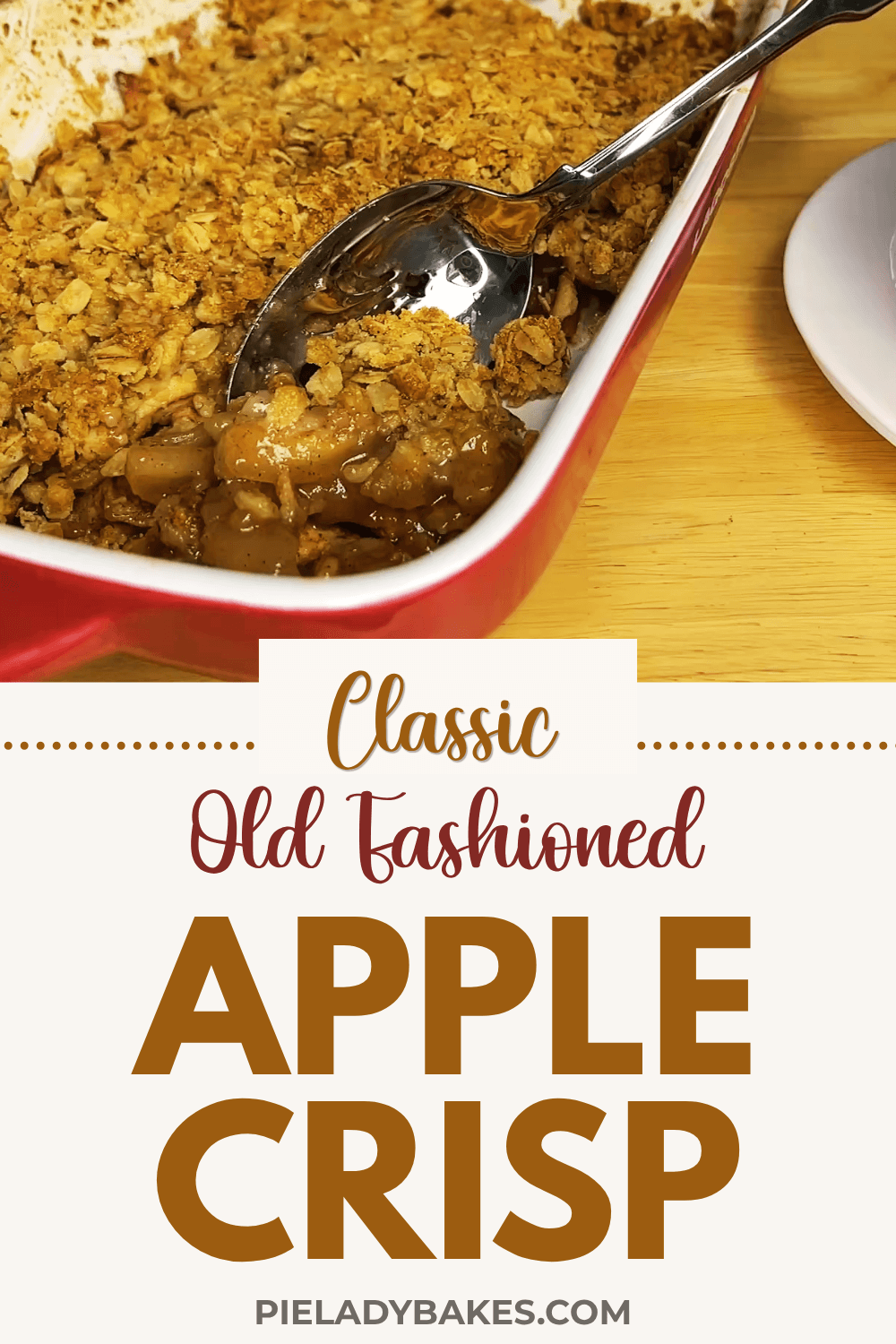 A dish of apple crisp with a serving spoon, featuring a golden oat topping and visible apple filling. Text on the image reads: “Classic Old Fashioned Apple Crisp, pieladybakes.com.” This easy apple crisp recipe perfectly showcases how to make a good apple crisp every time.