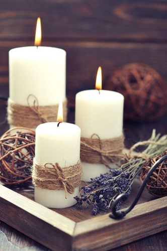 three white candles wrapped in jute on a wooden tray with lavender sprigs how to survive winter