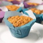spice cake muffins in blue and purple baking wrappers with a white dessert plate