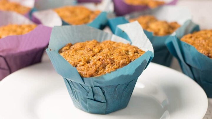spice cake muffins in blue and purple baking wrappers with a white dessert plate