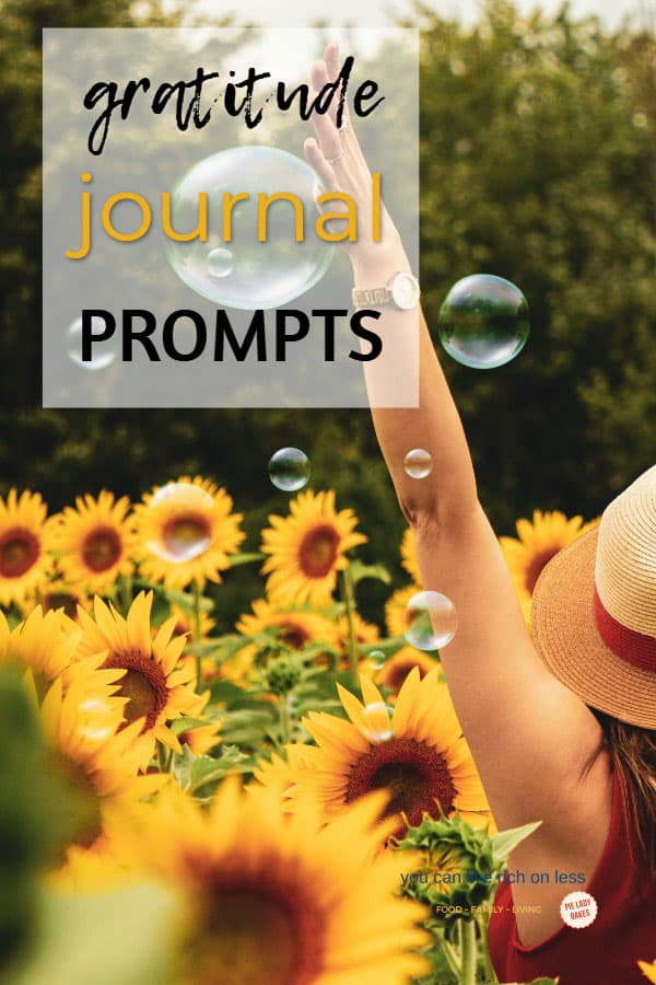 woman wearing a straw hat with arms outstretched standing in a field of sunflowers. text says gratitude in yellow type, with bubbles floating around here, and her back is to the camera
