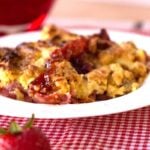 strawberry rhubarb crumble on a white plate with red checked placemat