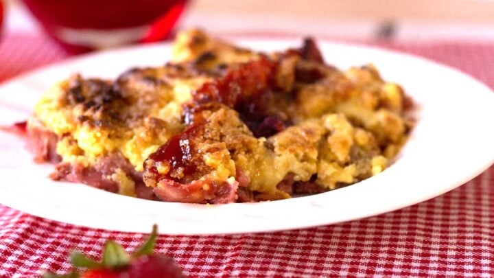 strawberry rhubarb crumble on a white plate with red checked placemat