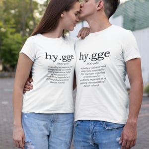 man and woman wearing white t shirts with the definition of hygge printed on them