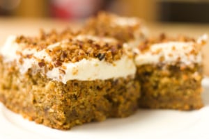 slices of carrot cake with cream cheese frosting on a white plate