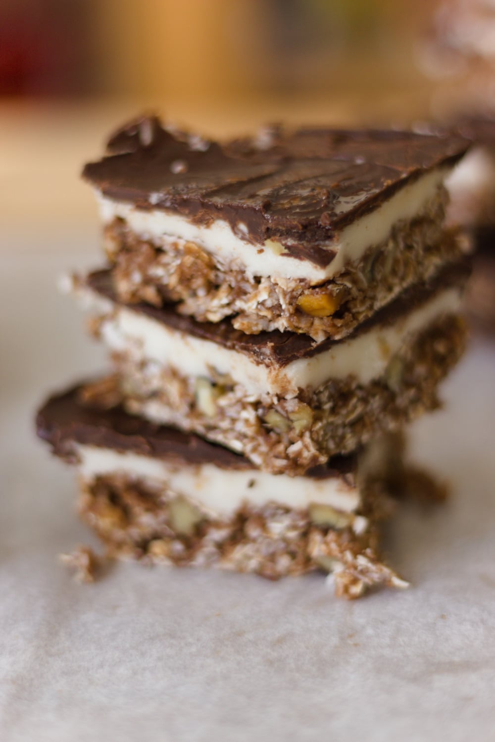 stack of 3 nanaimo bars on a white table blurred background