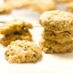 stack and single ranger cookies on a white counter with blurred out cookies on a cooling rack in background