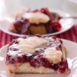 cherry dessert on white plate and red checked cloth