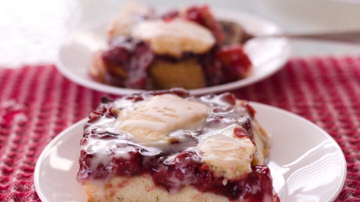 cherry dessert on white plate and red checked cloth