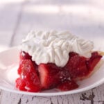 strawberry pie recipe with jello topped with whipped cream on white plate