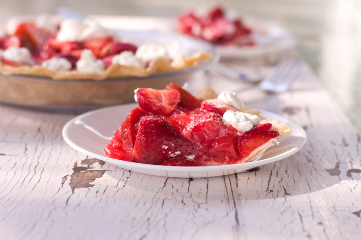 Slice of strawberry pie on white plate