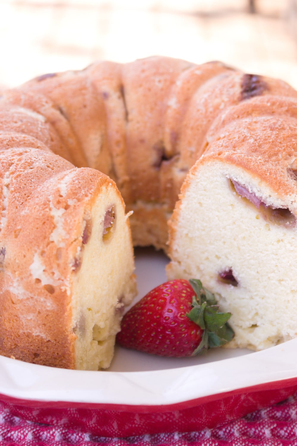 strawberry pound cake vertical with strawberry inside of cake