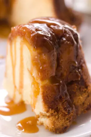slice of peach cobbler bundt cake dripping in caramel sauce closeup vertical