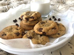 white plate with chocolate chip cookies and glass of milk