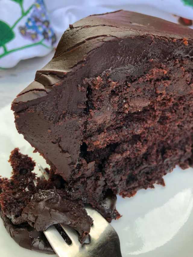 A slice of chocolate cake on a plate with a fork.