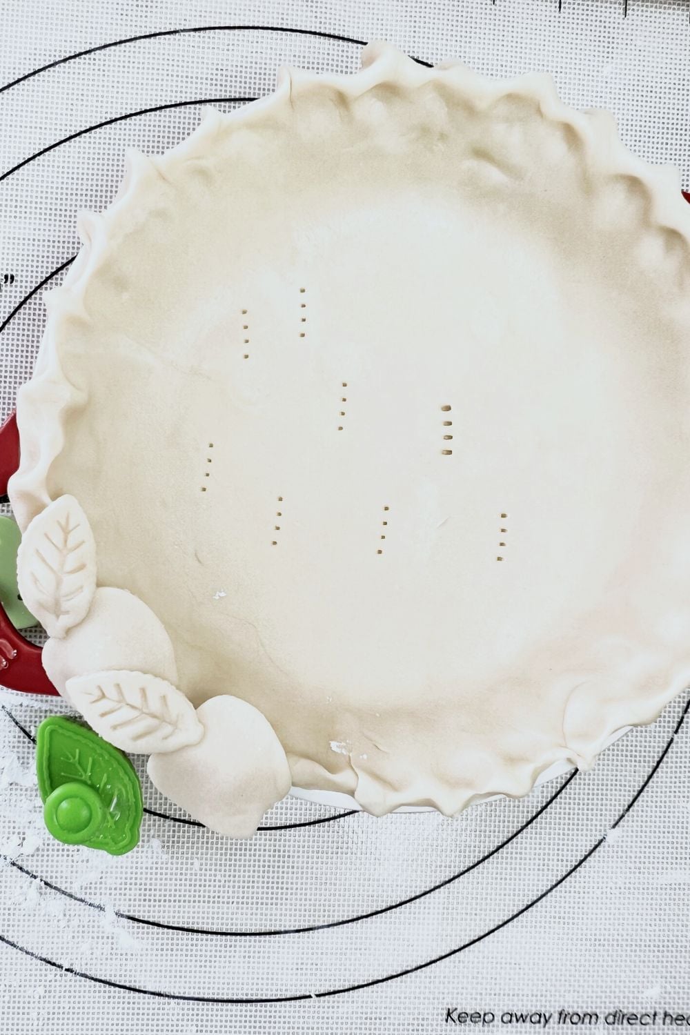 A pie crust is sitting on top of a baking sheet.