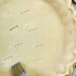 A fork is being used to cut a pie crust.