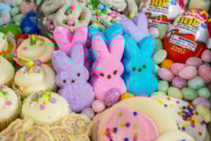 Colorful easter treats and candies, including marshmallow bunnies and decorated cupcakes.