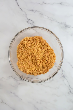 A bowl of brown sugar on a marble countertop, viewed from above.