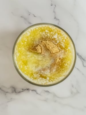 A bowl of rice pudding topped with cinnamon and served on a marble surface.