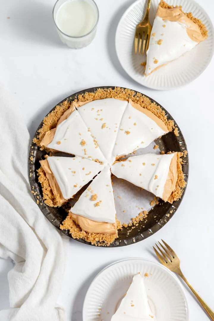 A delicious pie with a crumb crust and white topping is sliced and served on plates beside a glass of milk—perfect inspiration for National Pie Day or anyone searching for easy pie recipes.