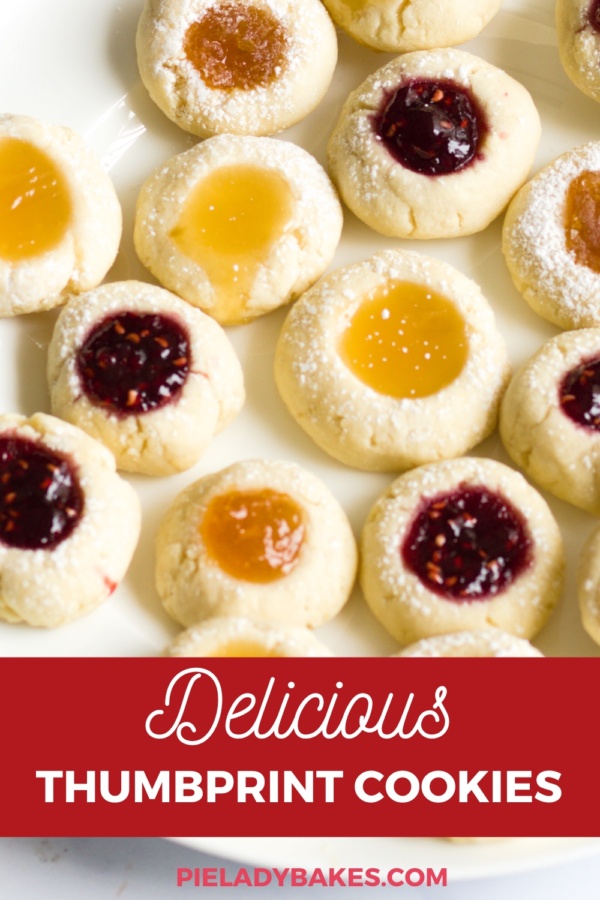 A plate of assorted thumbprint cookies filled with raspberry, apricot, and lemon jams, dusted with powdered sugar. Text reads: "Delicious Thumbprint Cookies.