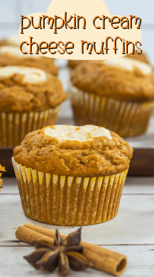 Pumpkin cream cheese muffins on a white surface with a cinnamon stick and star anise in the foreground.