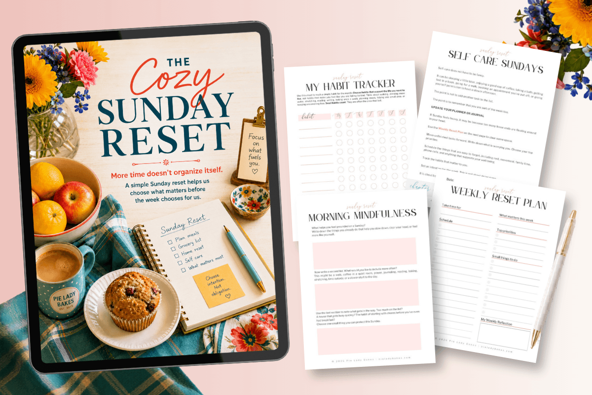 A digital tablet displays "The Cozy Sunday Reset" guide beside four printable planning sheets, tea, fruit, muffins, and flowers on a pastel background.